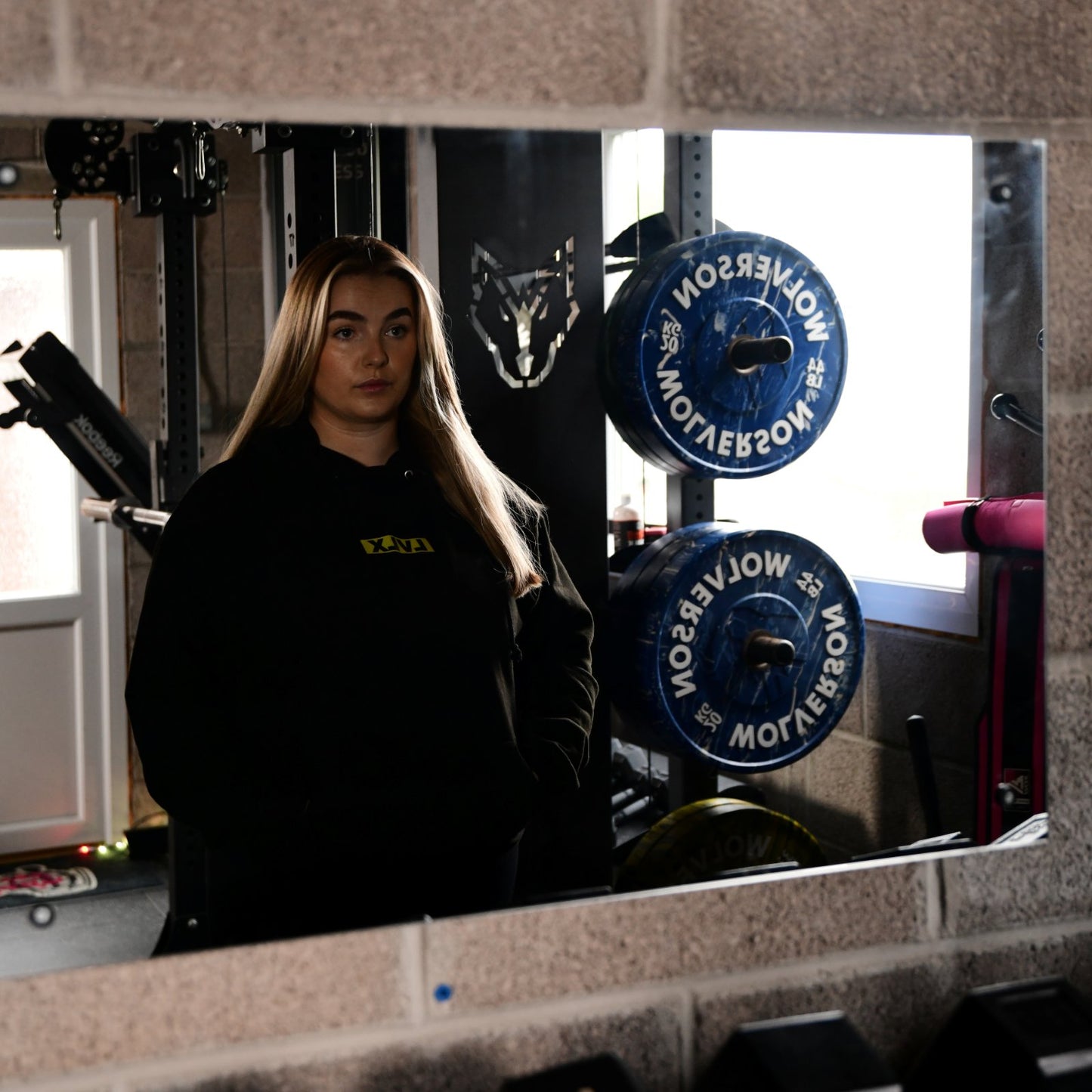 Female model wearing the LVLX hoodie in black, showing relaxed fit and logo on chest
